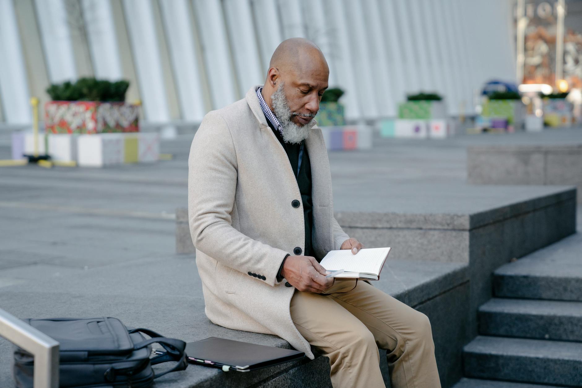 夕暮れ時に一人で座り、遠くを見つめる成熟した男性の後ろ姿