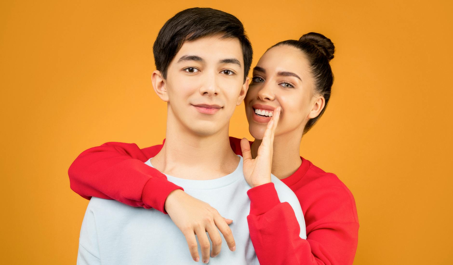 明るいカフェで笑顔で会話を楽しむ若いカップル